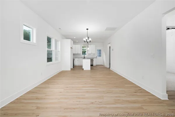 a view of a living room with kitchen island white wooden cabinets and window