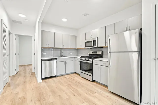 a kitchen with white cabinets and white appliances