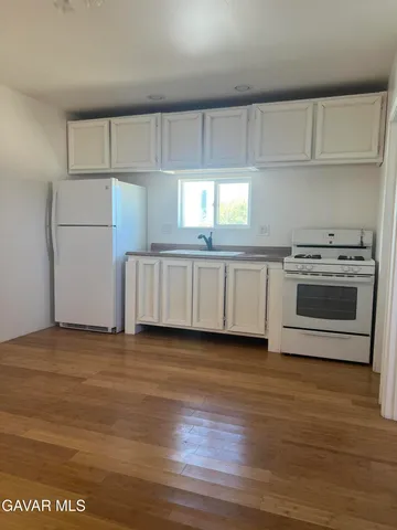 a view of a kitchen with a sink a stove and refrigerator