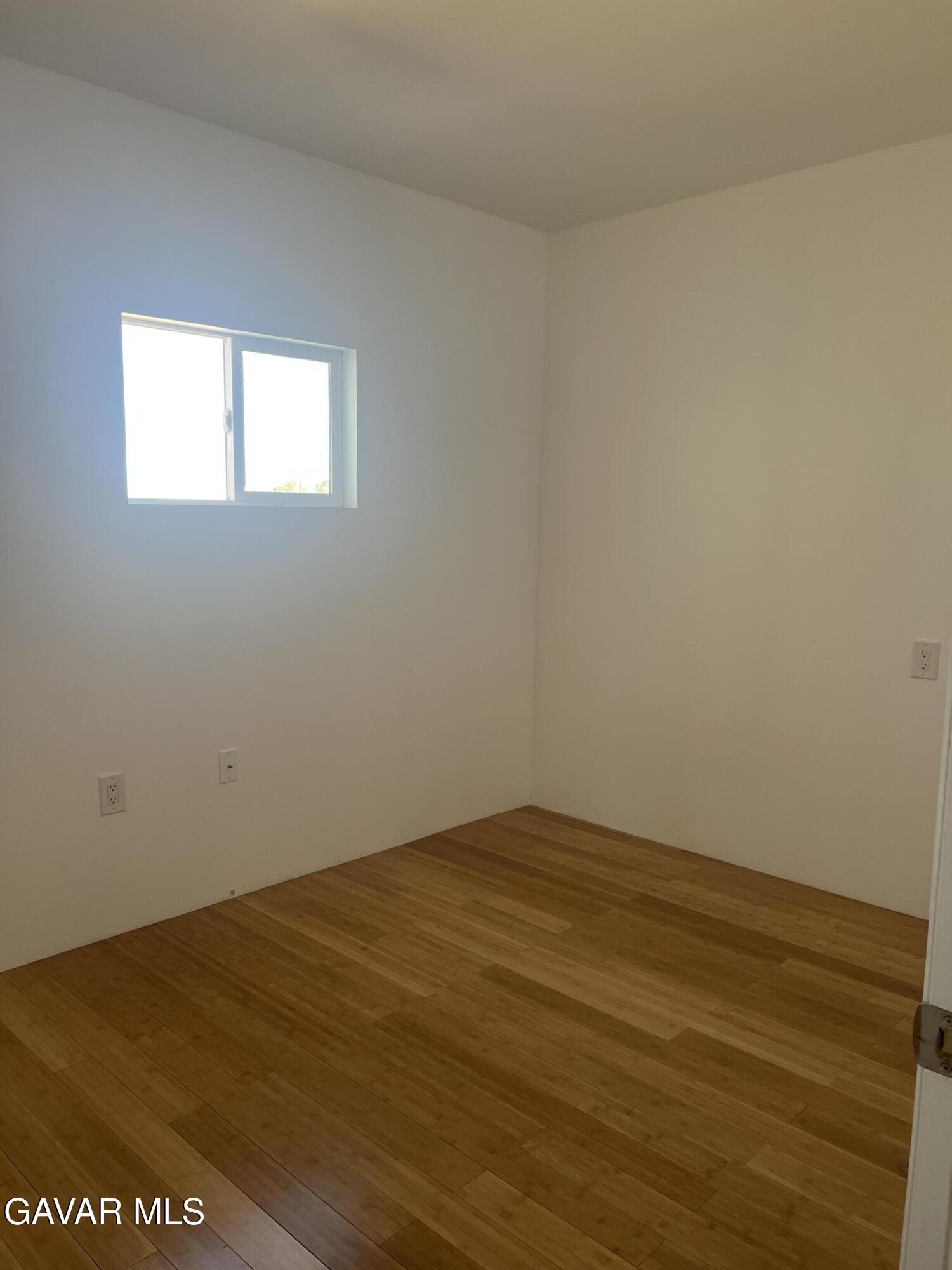9241 East Ave R 14 Littlerock, CA 93543 - Photo 7 of 10 a view of an empty room with wooden floor and a window