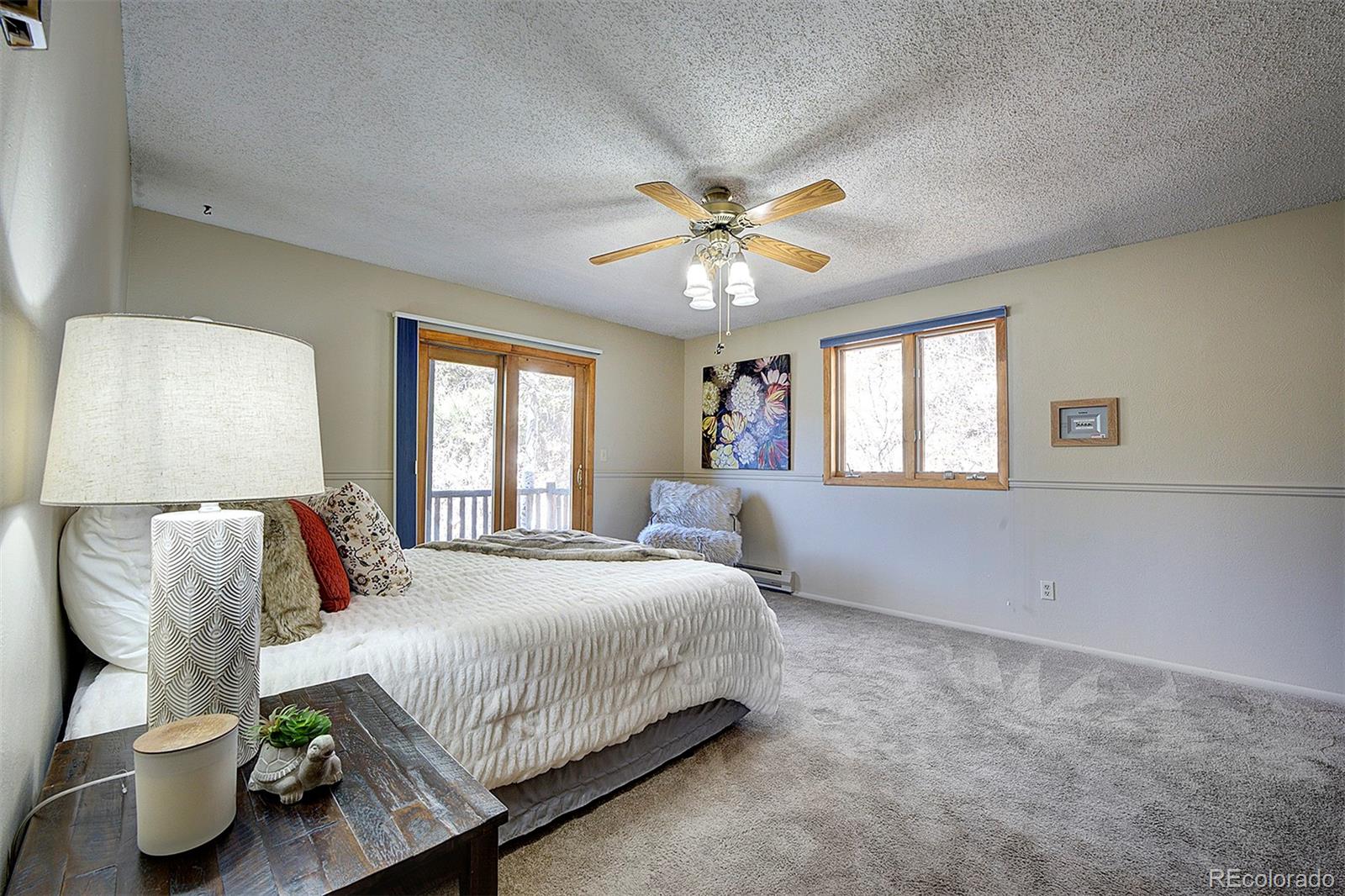 6561 Ridgeview Drive Morrison, CO 80465 - Photo 20 of 36 a bedroom with a bed and a chandelier