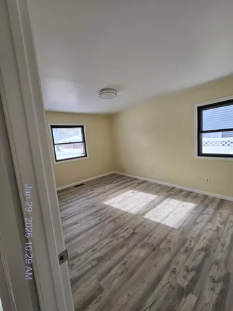 a view of a room with wooden floor and white walls