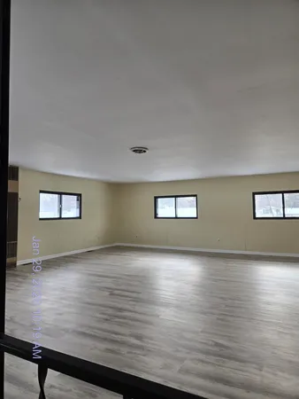 a view of a room with wooden floor and window