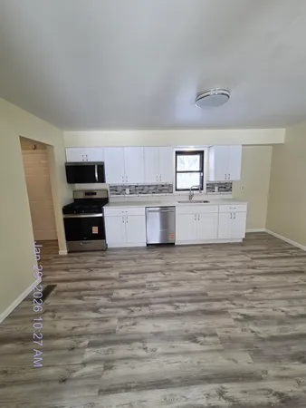a kitchen with granite countertop a stove top oven sink and cabinets