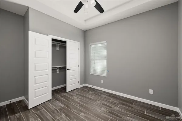 an empty room with closet and windows