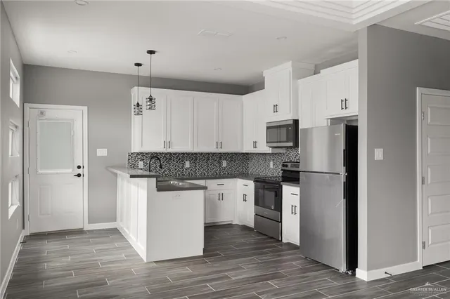 a kitchen with stainless steel appliances granite countertop a refrigerator and a stove top oven