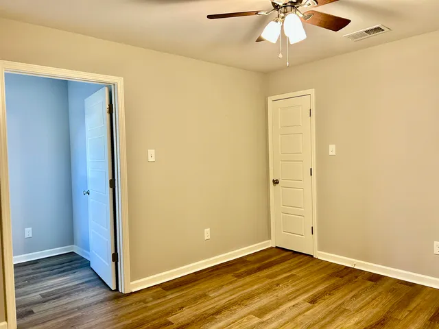 a view of an empty room with wooden floor