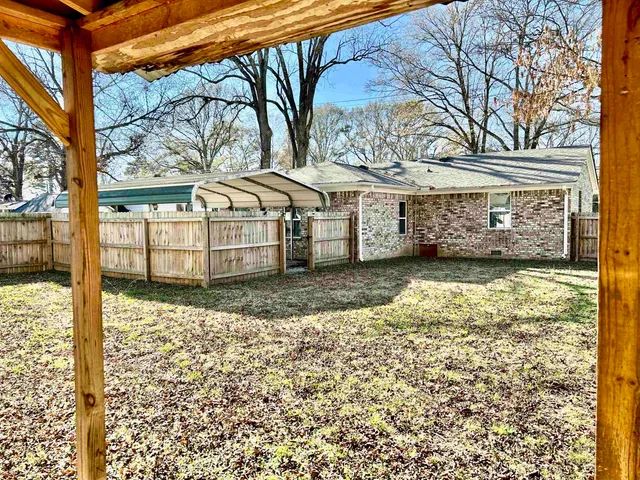 a view of a house with a large tree and a yard