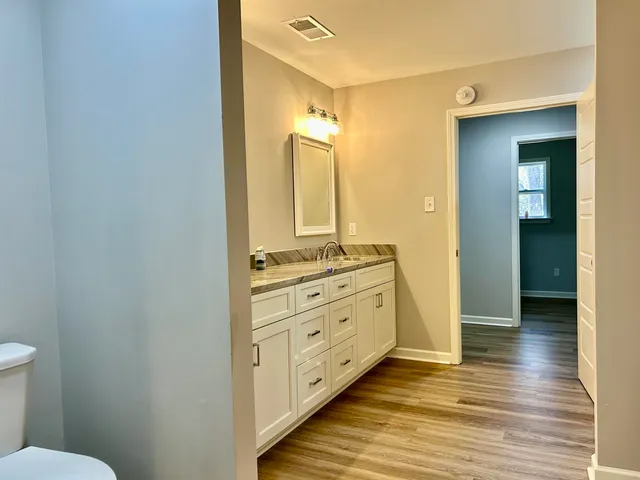 a bathroom with a granite countertop sink mirror and toilet