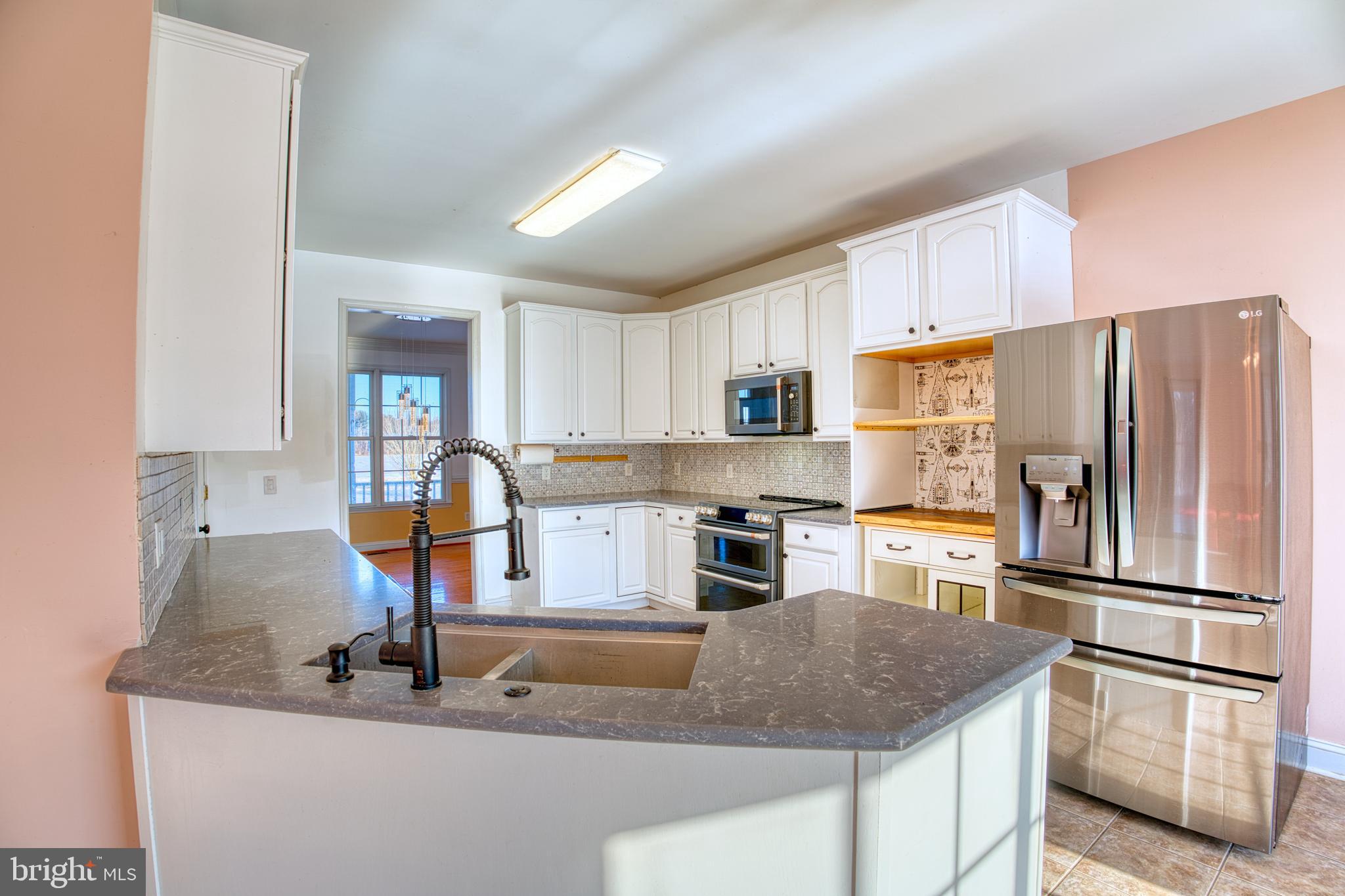 2412 Midstate Road Felton, DE 19943 - Photo 16 of 93 a kitchen with stainless steel appliances granite countertop a sink stove and refrigerator