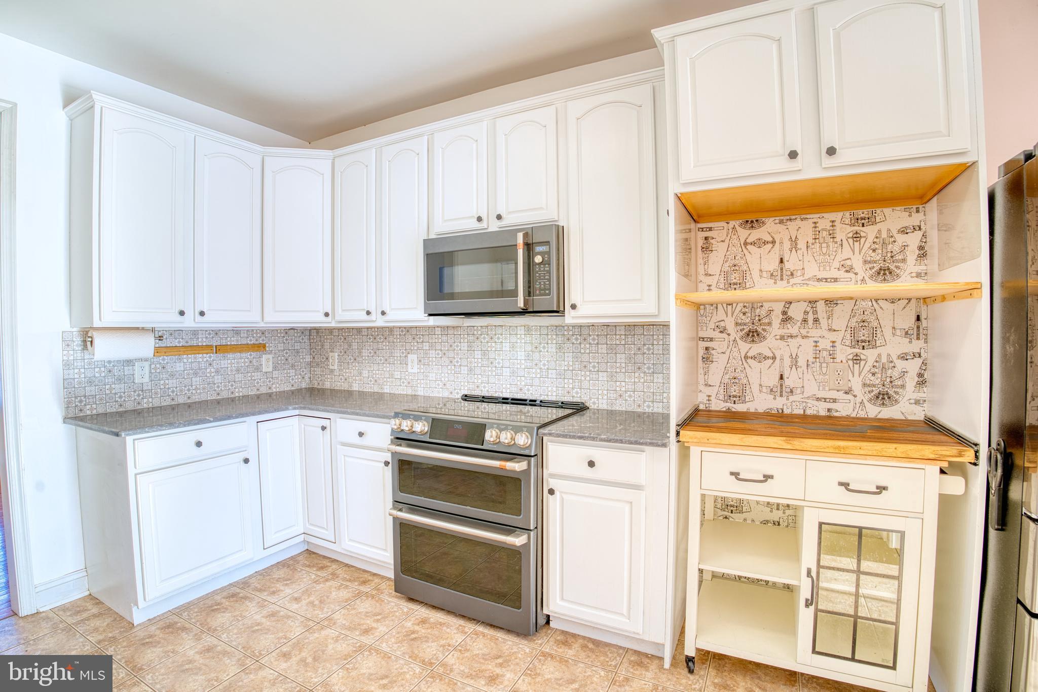 2412 Midstate Road Felton, DE 19943 - Photo 17 of 93 a kitchen with stainless steel appliances granite countertop a stove and a microwave
