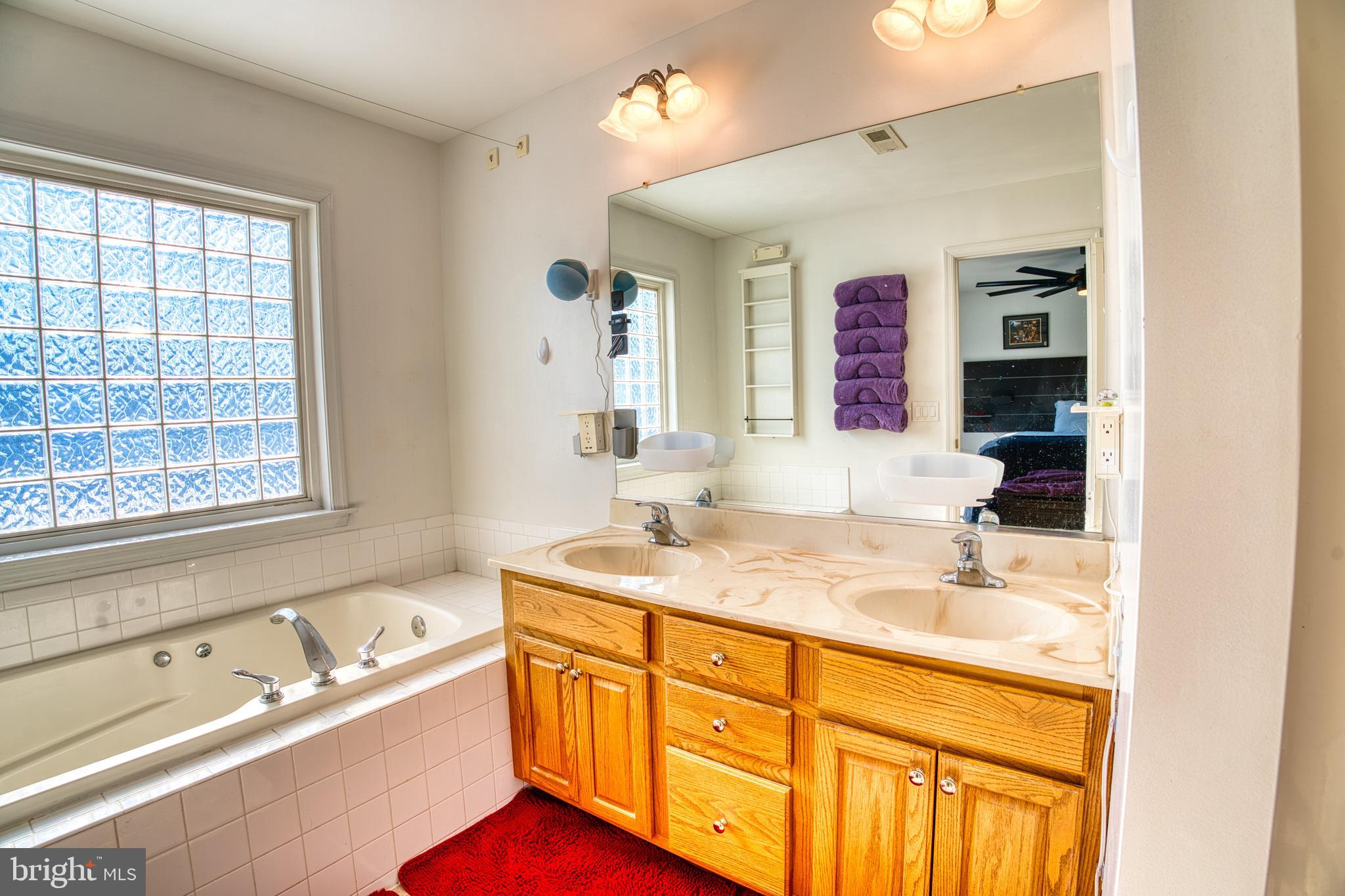 2412 Midstate Road Felton, DE 19943 - Photo 54 of 93 a bathroom with a sink double vanity granite tub shower and a mirror