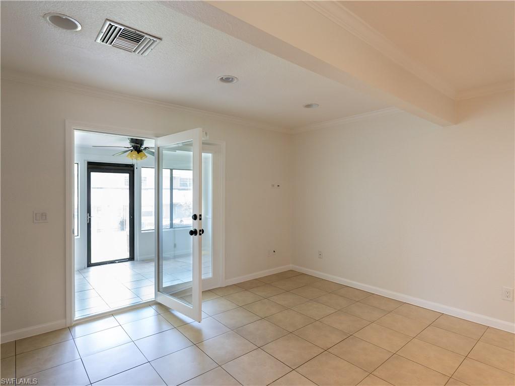 11001 Southeast Sunset Harbor Road, Unit 34 Summerfield, FL 34491 - Photo 11 of 31 Spare room with beamed ceiling, ceiling fan, french doors, and light tile floors