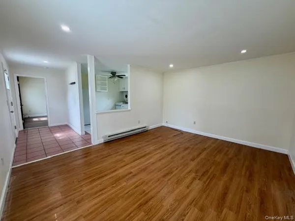 an empty room with wooden floor and bathroom