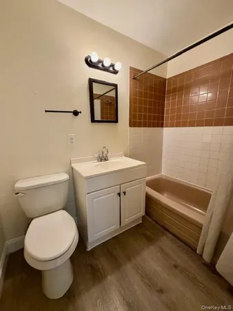 a bathroom with a toilet a sink and mirror