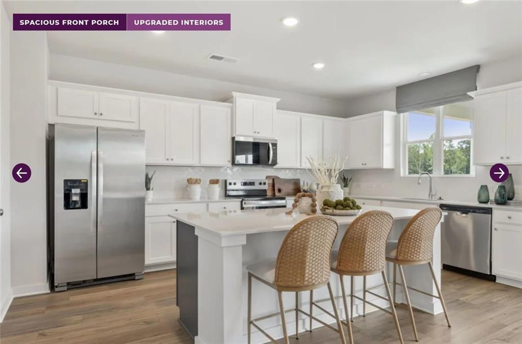 30 Poplar Blf Way Jefferson, GA 30549 - Photo 6 of 31 a kitchen with stainless steel appliances granite countertop a refrigerator a stove a sink and white cabinets with wooden floor