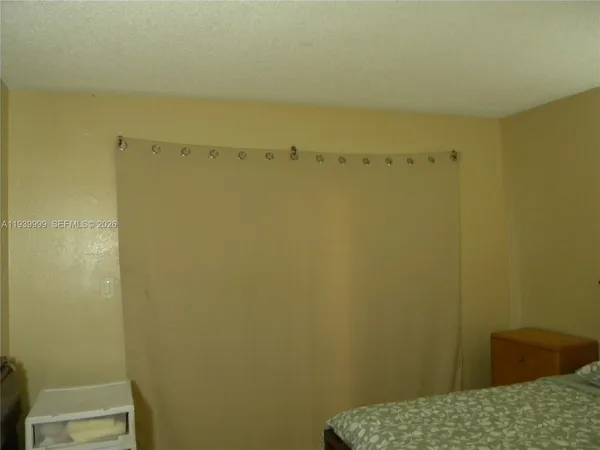 a bedroom with a bed and dresser with mirror