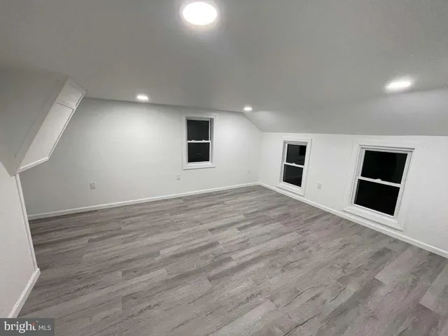 a view of empty room with wooden floor and fireplace