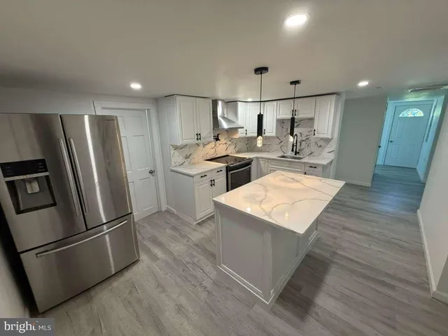 a kitchen with stainless steel appliances granite countertop a refrigerator a stove a sink dishwasher and a refrigerator with wooden floor