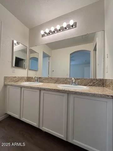 a bathroom with a granite countertop sink and a mirror