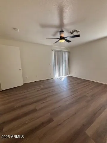 a view of a livingroom with wooden floor and a ceiling fan