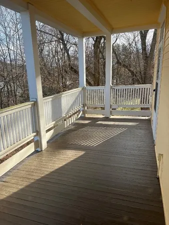 a view of a balcony with a floor to ceiling window and wooden fence