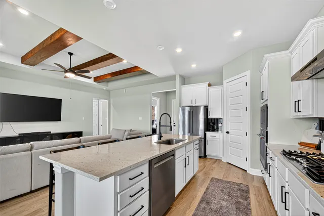 a kitchen with stainless steel appliances kitchen island granite countertop a stove and a sink