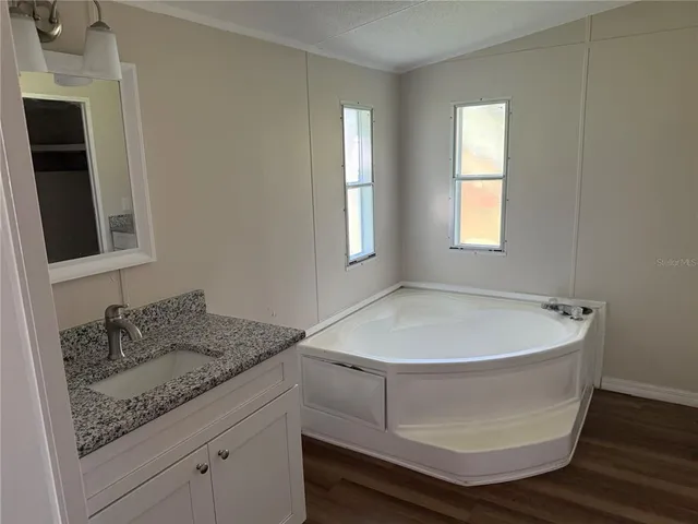 a bathroom with a granite countertop sink and mirror