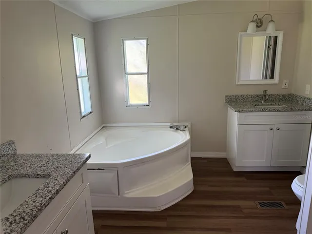 a spacious bathroom with a granite countertop sink and a mirror