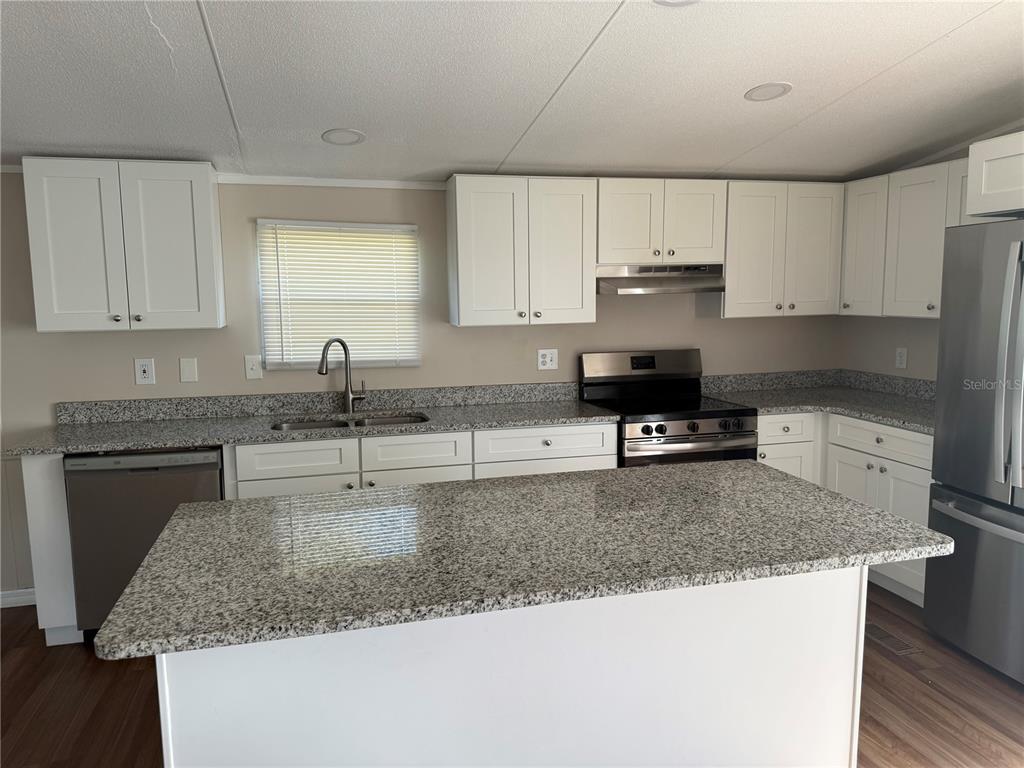 4113 Shady View Run Mulberry, FL 33860 - Photo 2 of 17 a kitchen with granite countertop a sink a stove and cabinets