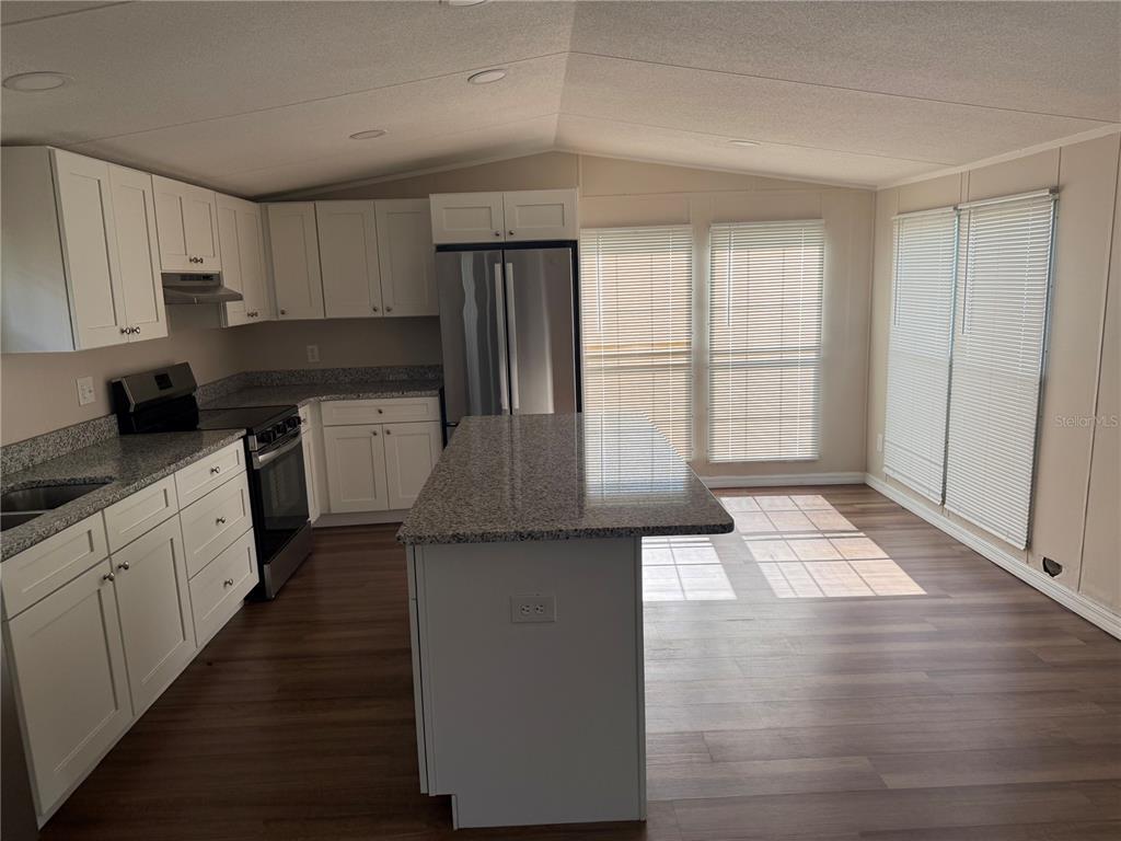 4113 Shady View Run Mulberry, FL 33860 - Photo 5 of 17 a kitchen with granite countertop a refrigerator and a stove top oven