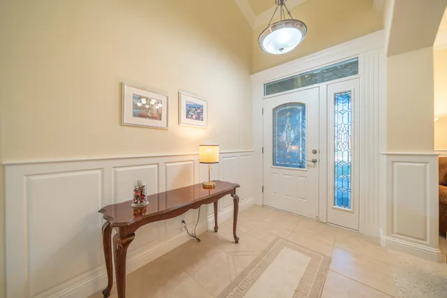 a kitchen with stainless steel appliances kitchen island granite countertop a dining table chairs and a refrigerator