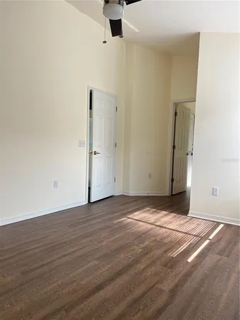 a view of an empty room with wooden floor