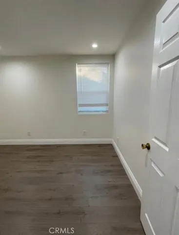 a view of a room with wooden floor and window