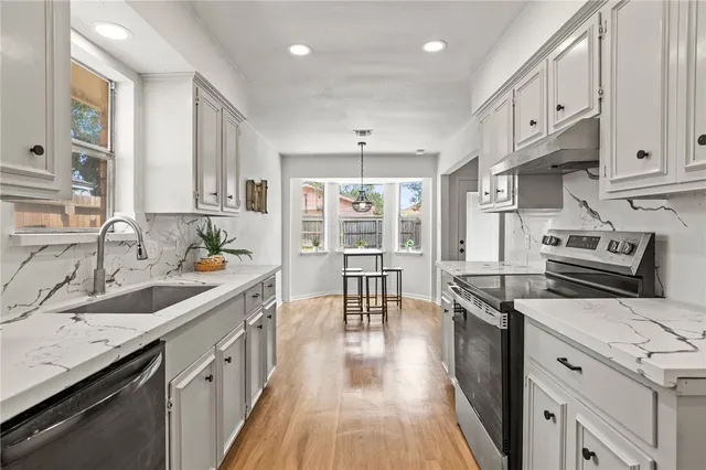 a kitchen with stainless steel appliances granite countertop a sink stove and refrigerator