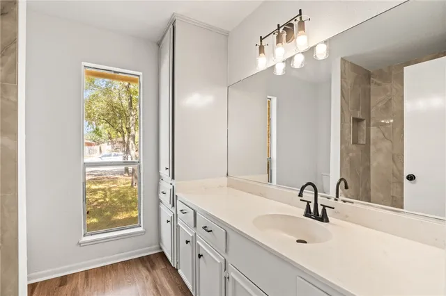 a bathroom with a double vanity sink window and a mirror