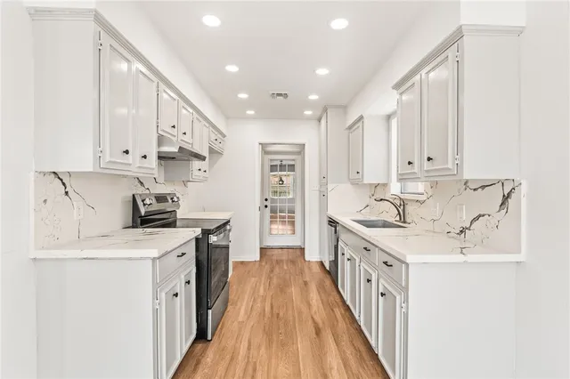 a kitchen with stainless steel appliances granite countertop a sink stove and refrigerator