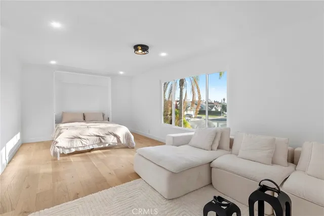 a bedroom with furniture and a large window