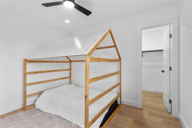 a bed room with a bed and a ceiling fan