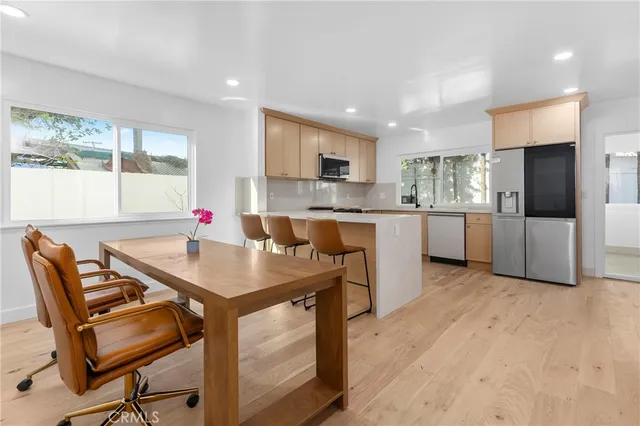 a kitchen with a table chairs microwave and cabinets