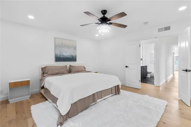 a bedroom with a large bed and a chandelier