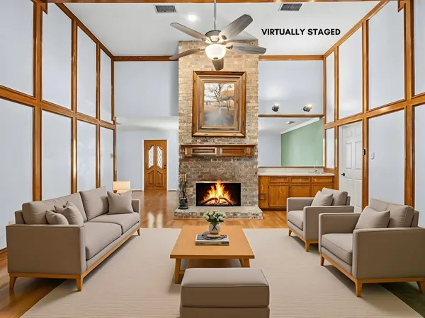 a living room with furniture fireplace and a large window