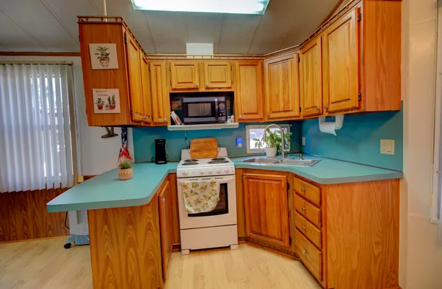 a kitchen with stainless steel appliances granite countertop a sink a microwave cabinets and a refrigerator