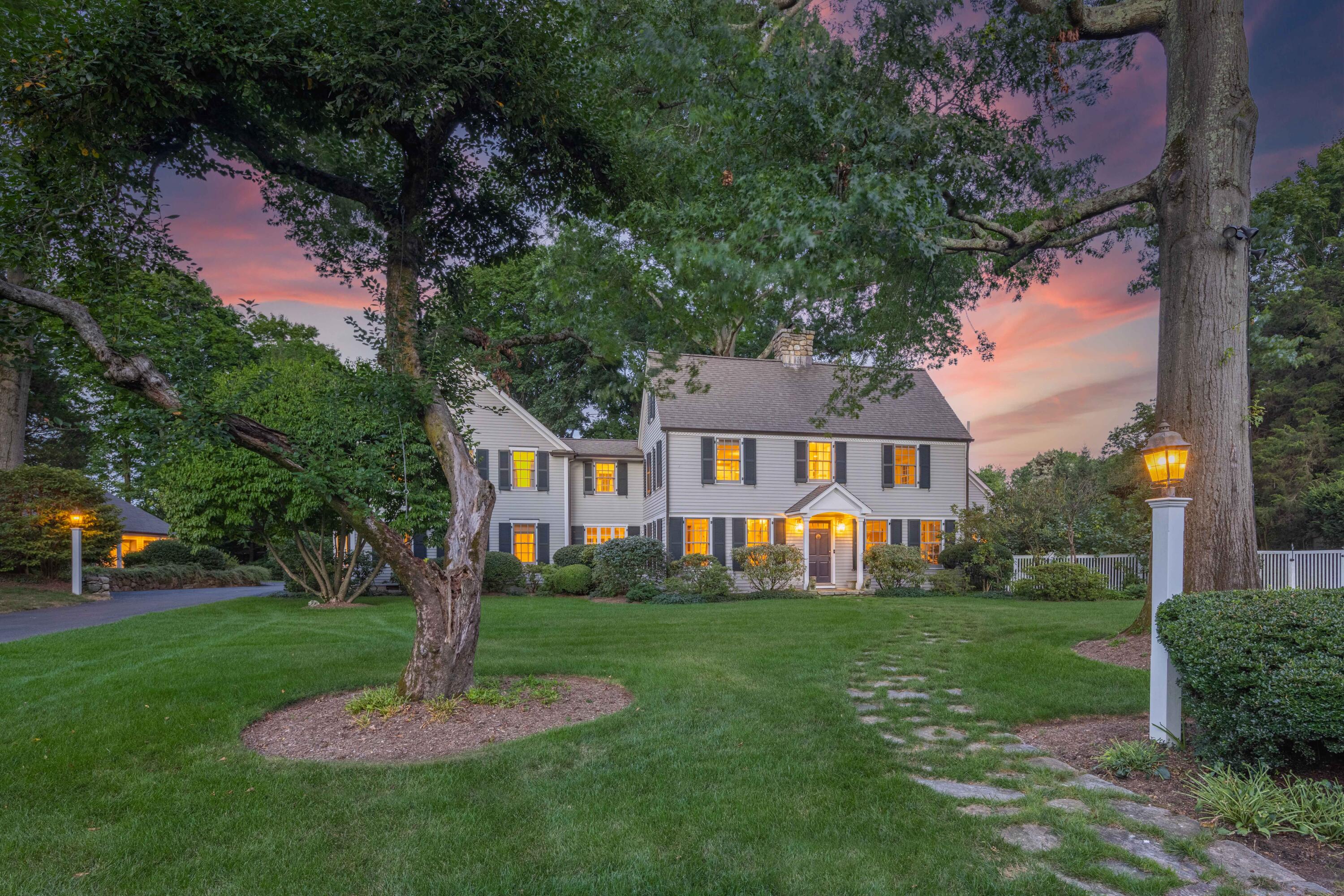 a front view of a house with a yard garden and tree