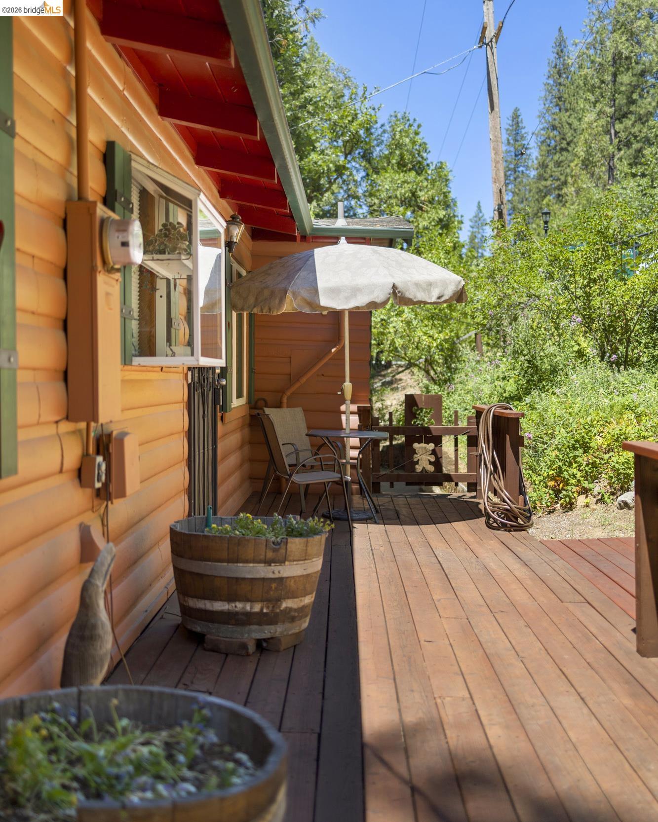 21815 Confidence Road Twain Harte, CA 95383 - Photo 29 of 30 a view of a patio with couches table and chairs under an umbrella with a barbeque