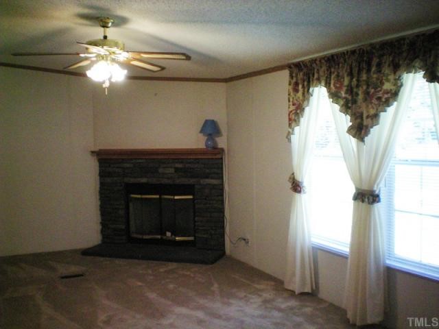 7422 Jock Road Bahama, NC 27503 - Photo 6 of 12 a living room with a fireplace and a chandelier