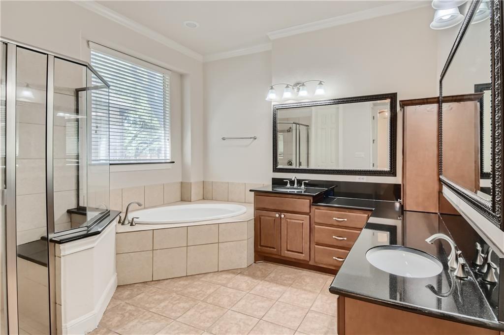3822 Remington Road Cedar Park, TX 78613 - Photo 18 of 31 a bathroom with a double vanity sink a mirror and a bathtub