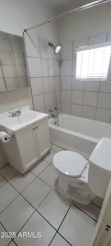 an empty room with wooden floor chandelier fan and windows