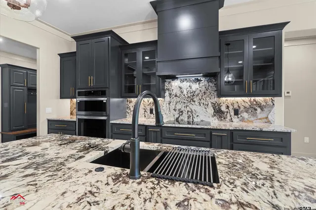 a kitchen area with granite countertop a refrigerator and cabinets