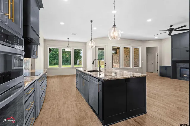 a large kitchen with granite countertop a large counter top space appliances and cabinets